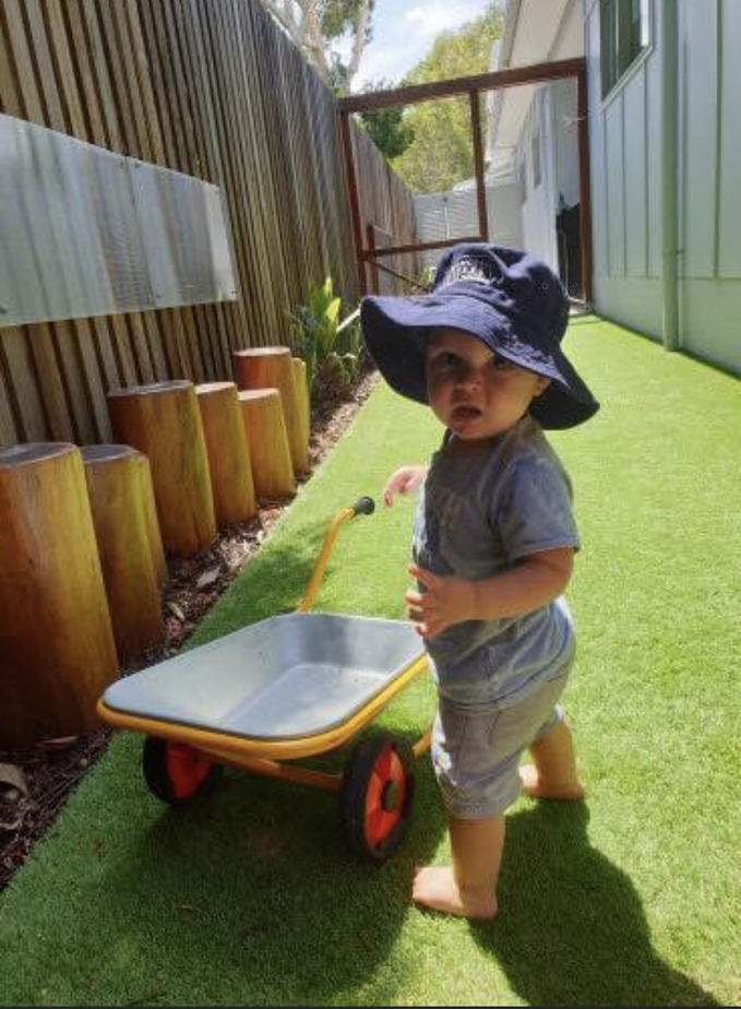 Child playing with wheelbarrow