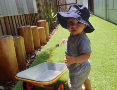 Child playing with wheelbarrow