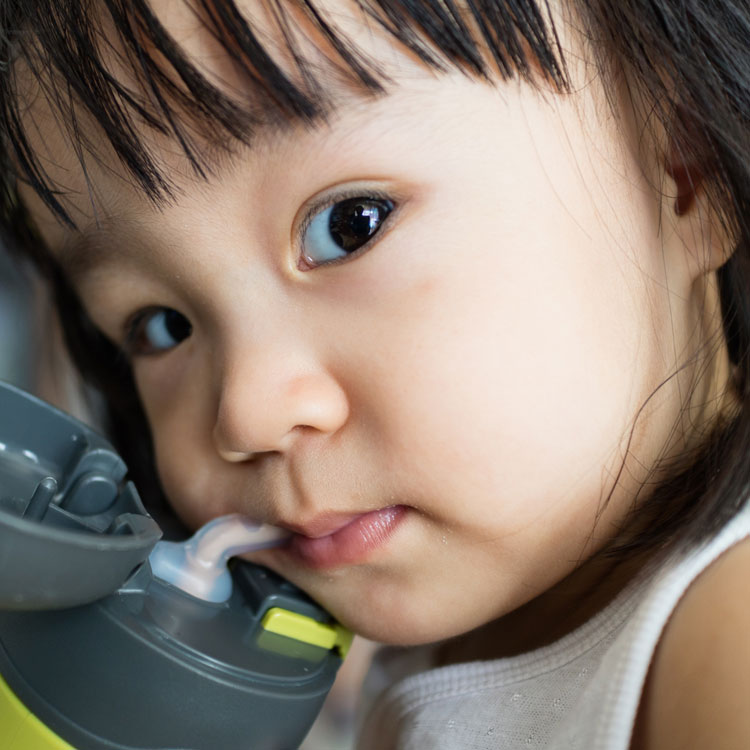 child drinking from waterbottle